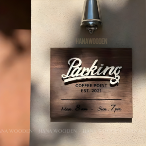 Wooden sign engraved with house number, company name, shop name, and opening hours.